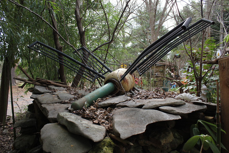 Metal sculpture on a stone base in the woods