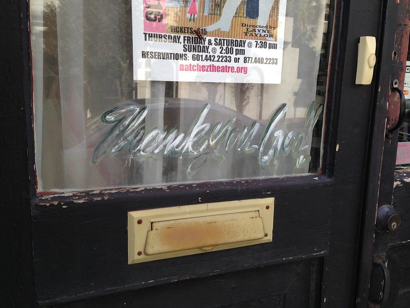 Black door with etched glass and a brass mail slot
