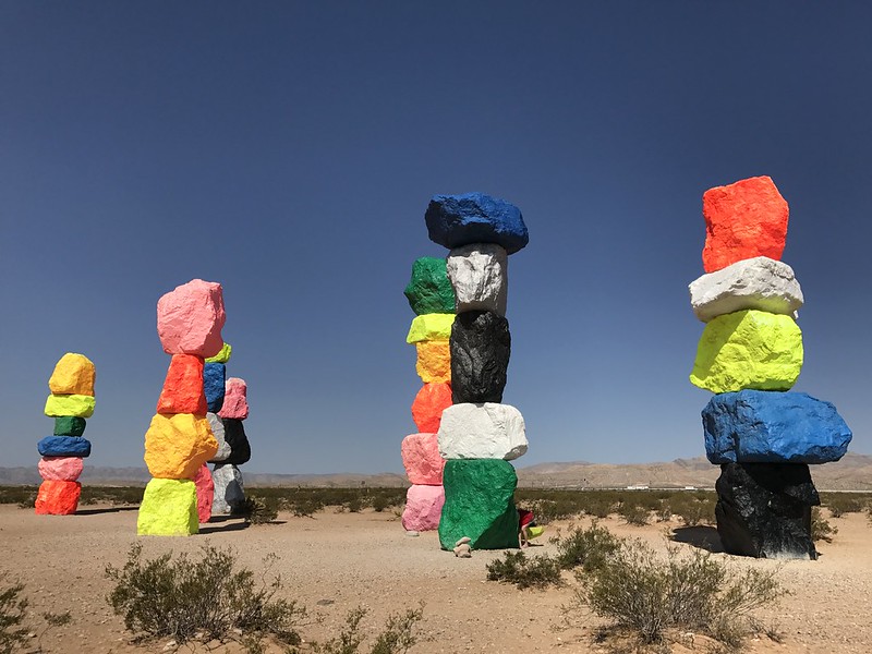 Stacked boulders painted in neon colors in the desert